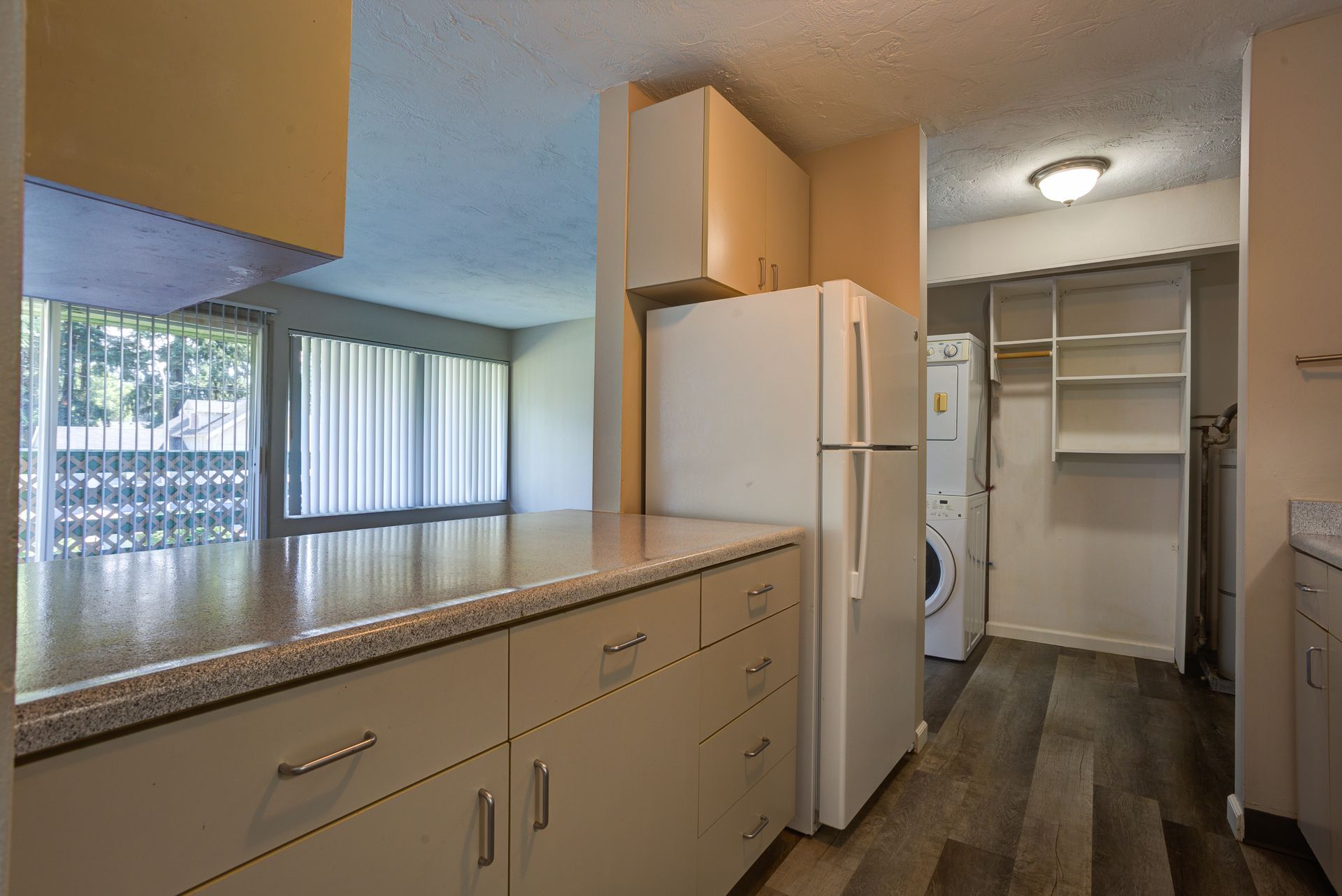 A kitchen with a refrigerator and a washer and dryer
