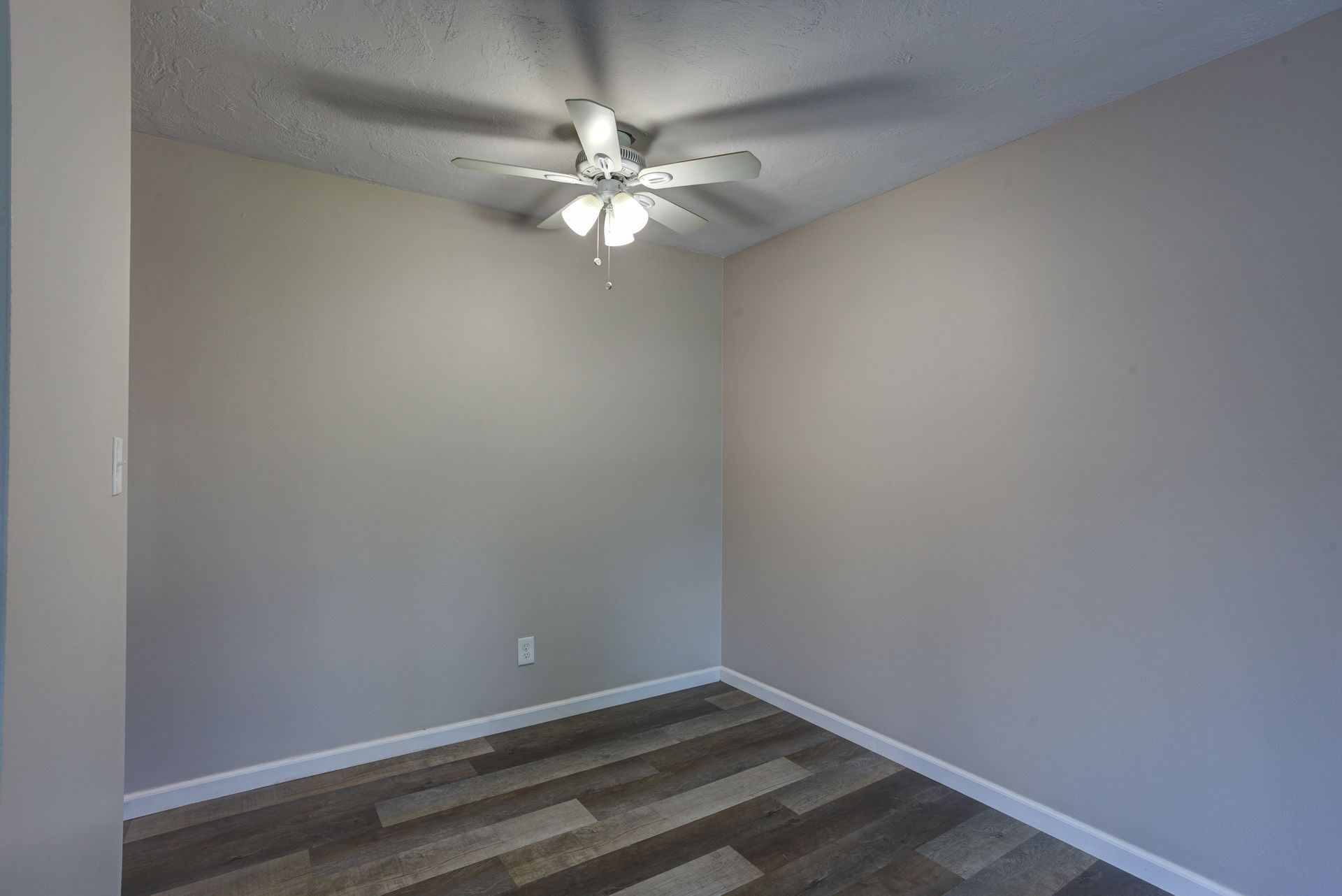 There is a ceiling fan in the corner of the room.