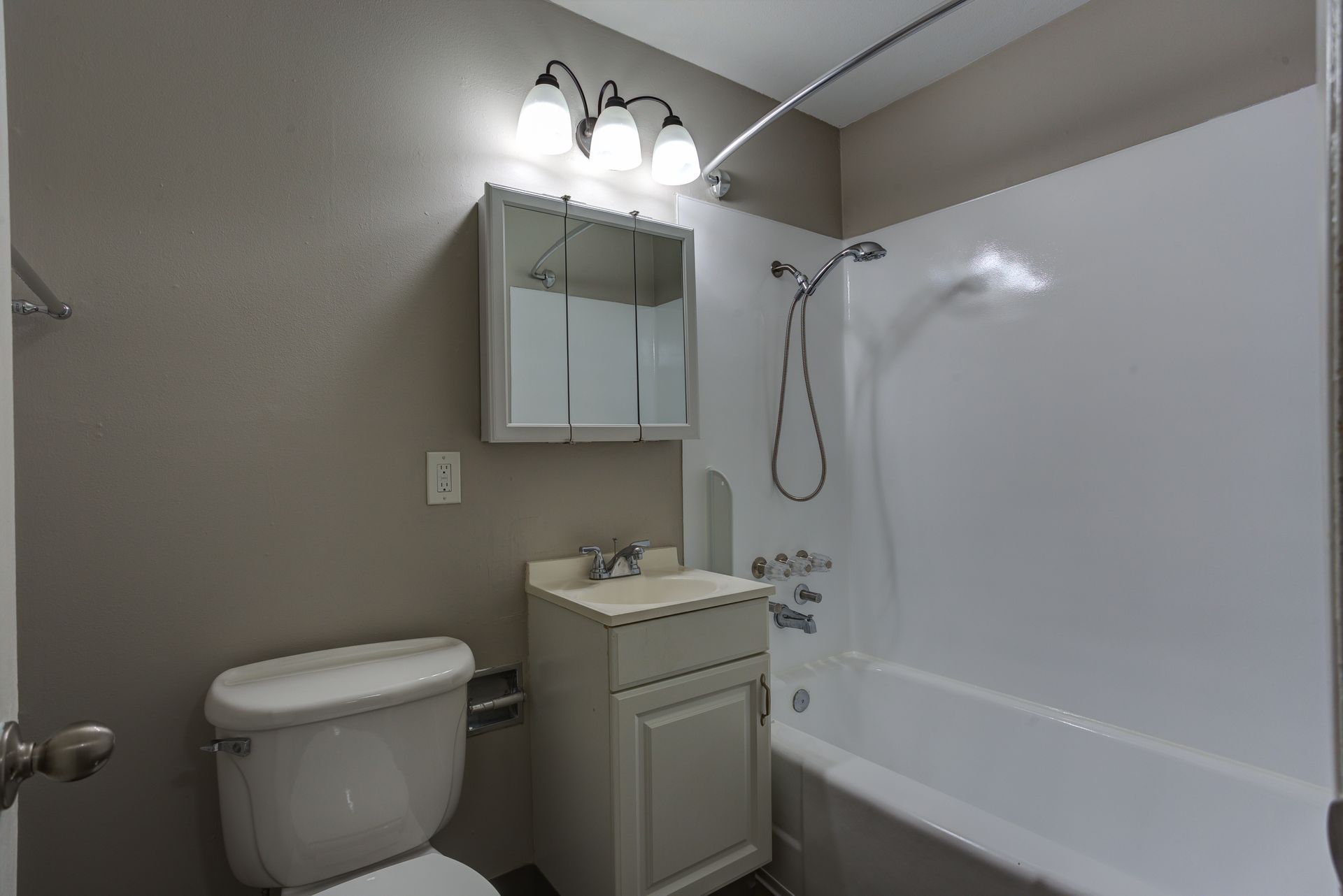 A bathroom with a toilet , sink , and bathtub.