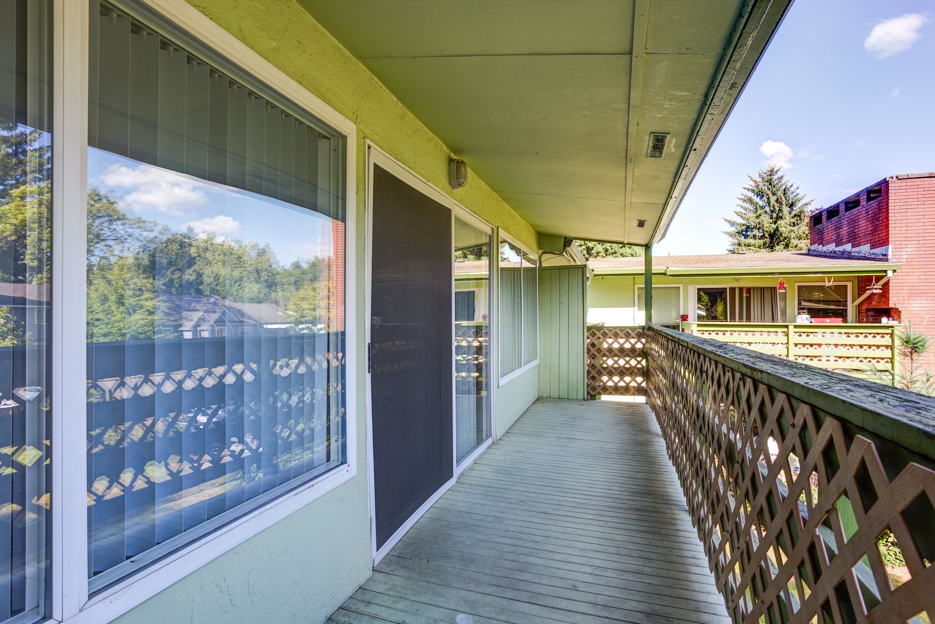 A balcony with sliding glass doors and a wooden railing