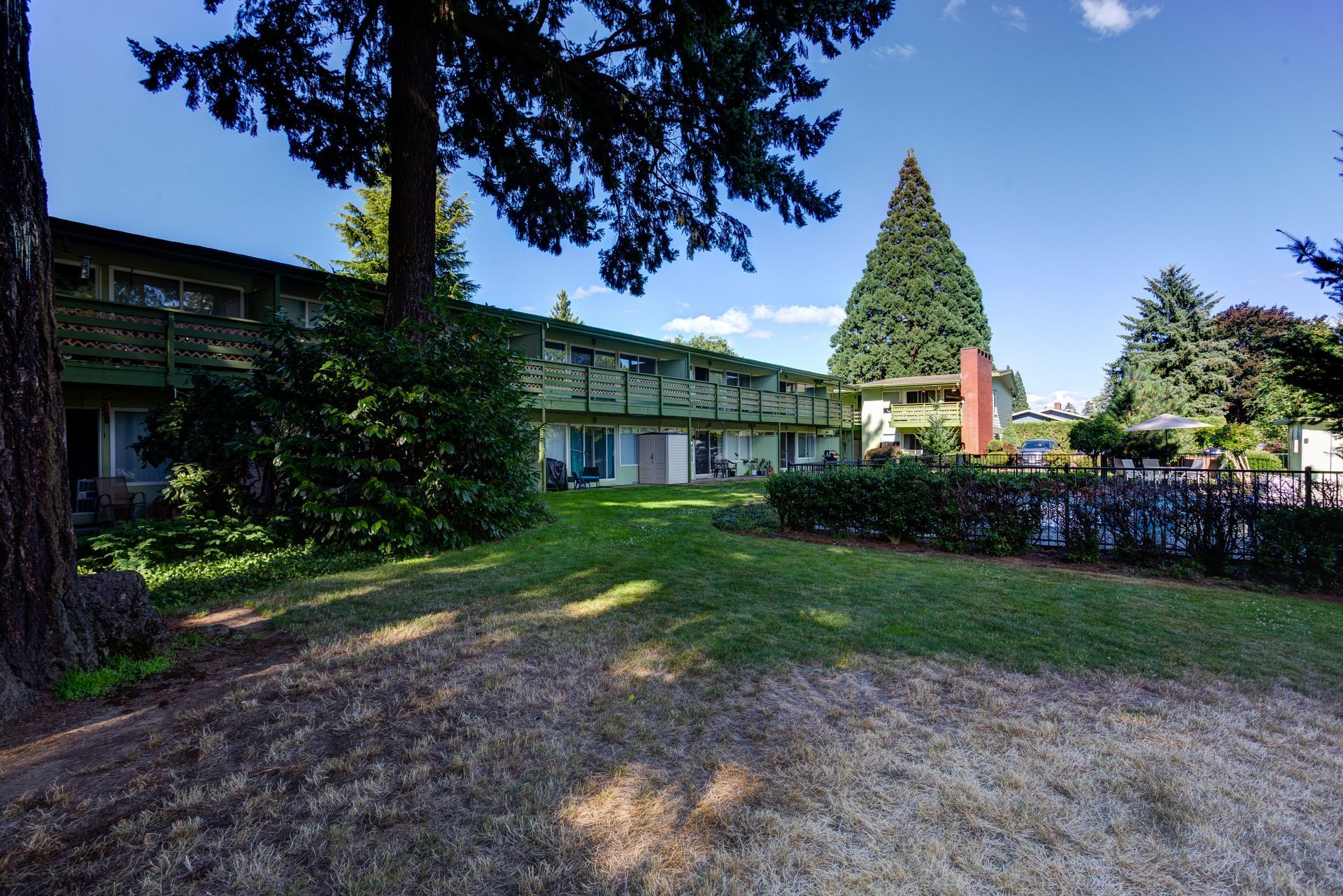 A large building with a lot of grass and trees in front of it
