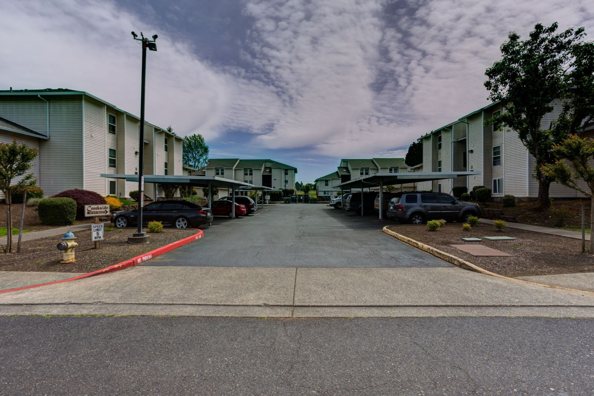 A row of apartment buildings with cars parked in front of them
