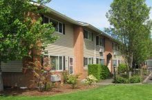A large apartment building with a lot of windows and trees in front of it.