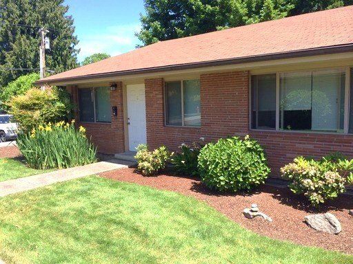 A brick house with a red roof and a white door