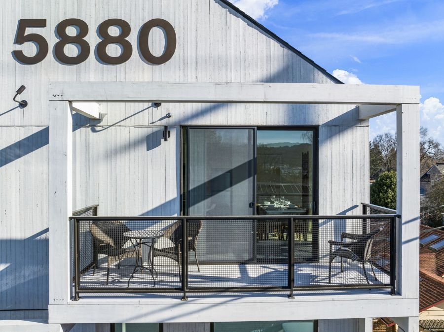 There is a balcony with a table and chairs on it.