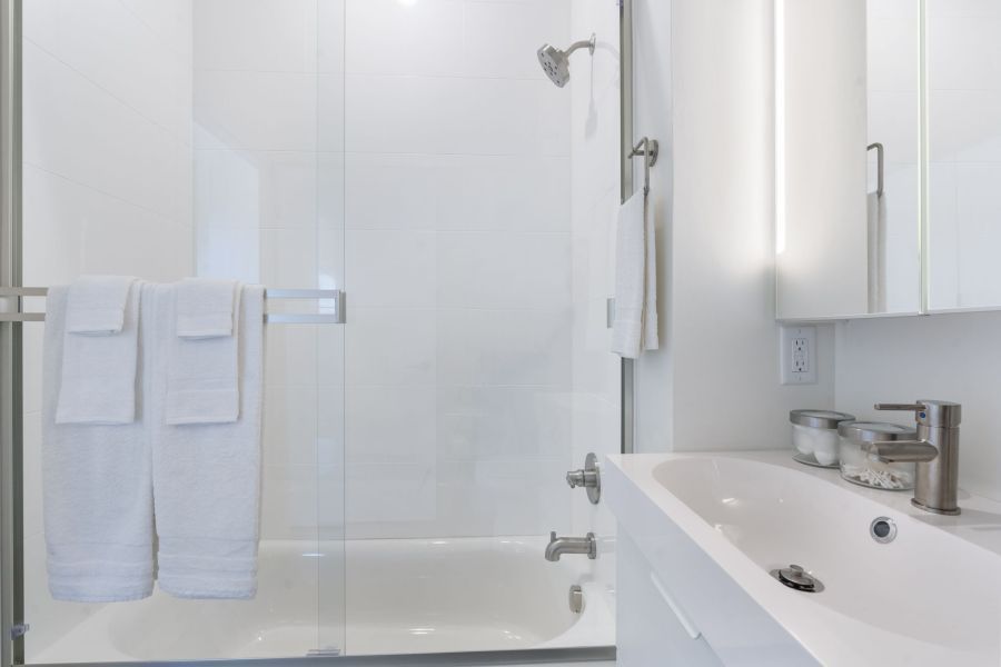 A bathroom with a sink , tub , shower and mirror.
