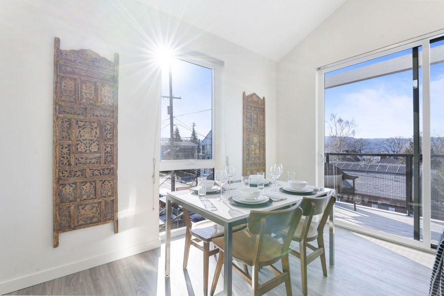 A dining room with a table and chairs and a sliding glass door.