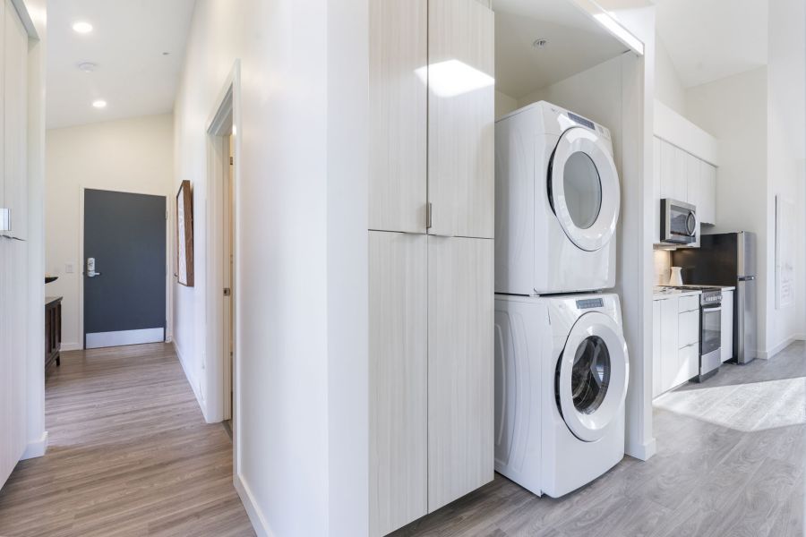 A washer and dryer are stacked on top of each other in a laundry room.