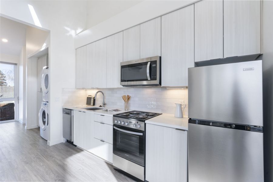A kitchen with stainless steel appliances and white cabinets