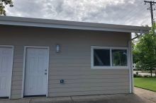 A small house with two white doors and a window.