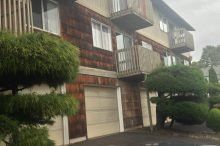 A large apartment building with a lot of windows and trees in front of it.
