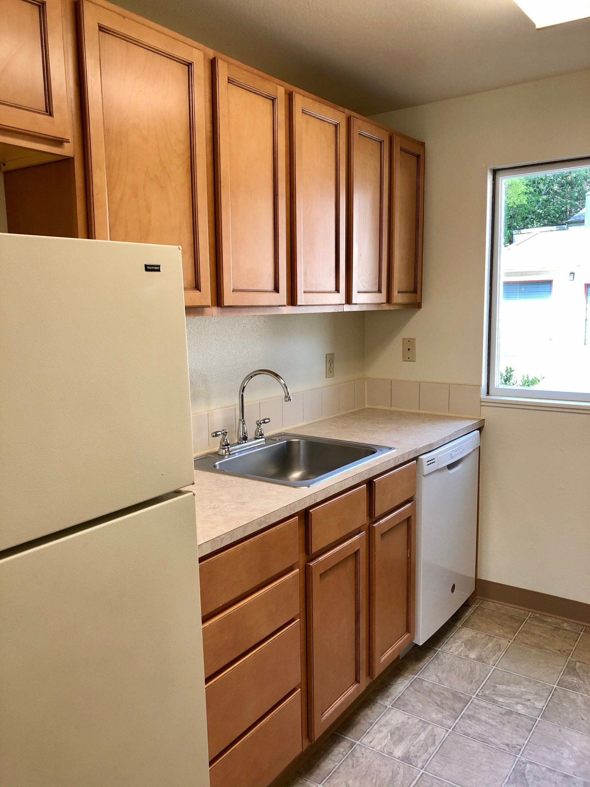 A kitchen with wooden cabinets and a white refrigerator