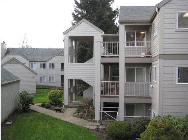 A large apartment building with a lawn in front of it