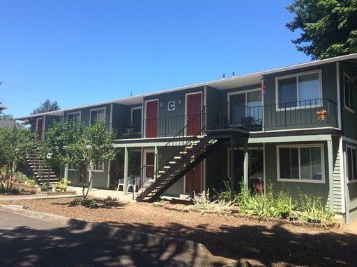 A large apartment building with stairs leading up to the second floor.