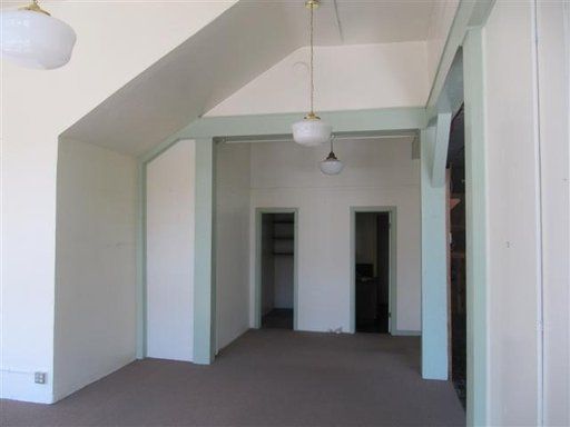An empty room with a vaulted ceiling and white walls