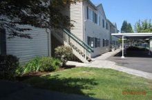 A building with stairs and a carport in front of it.