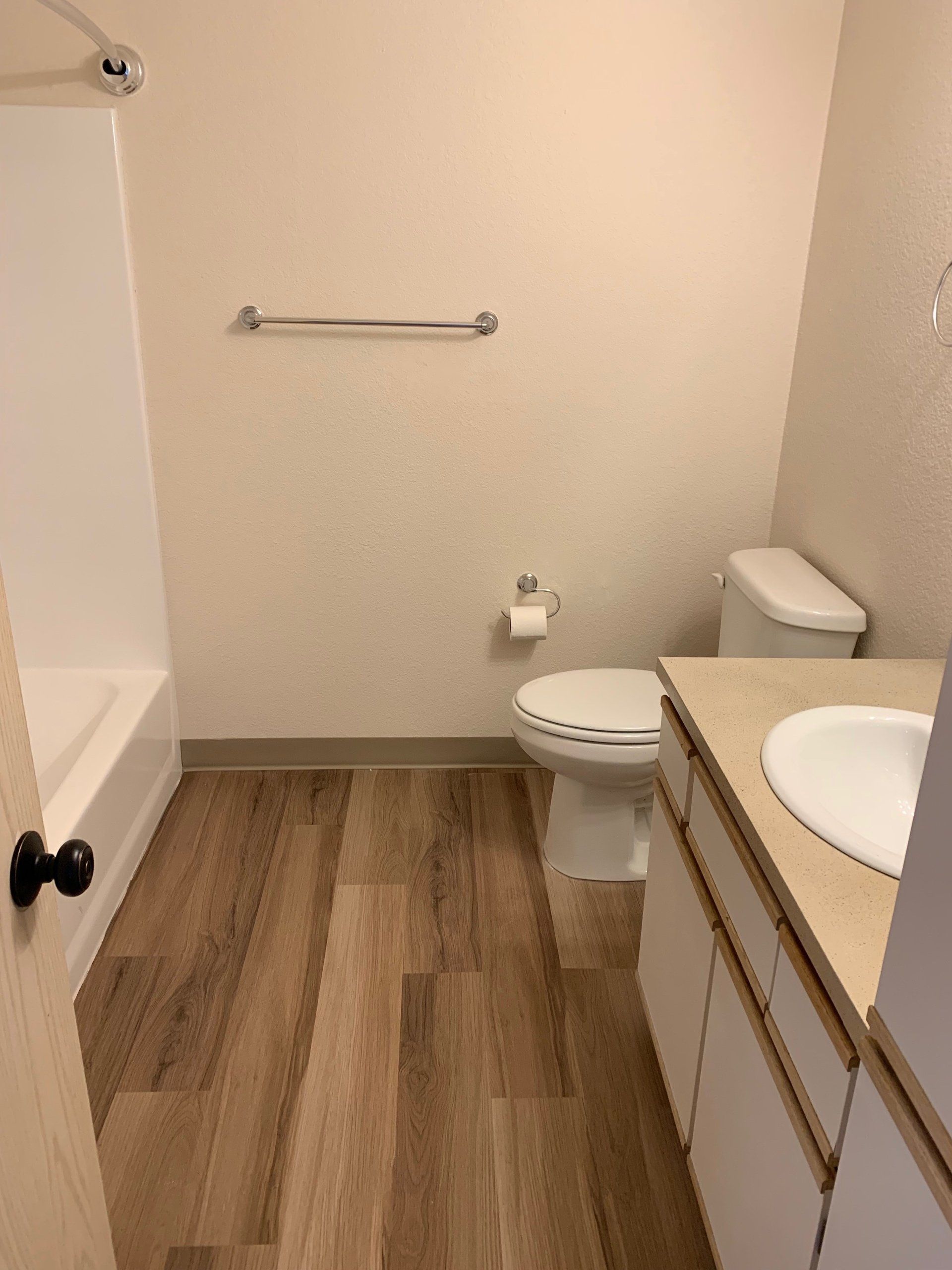A bathroom with a toilet , sink and shower.