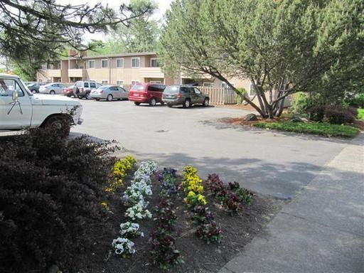 A white truck is parked in a parking lot in front of a building