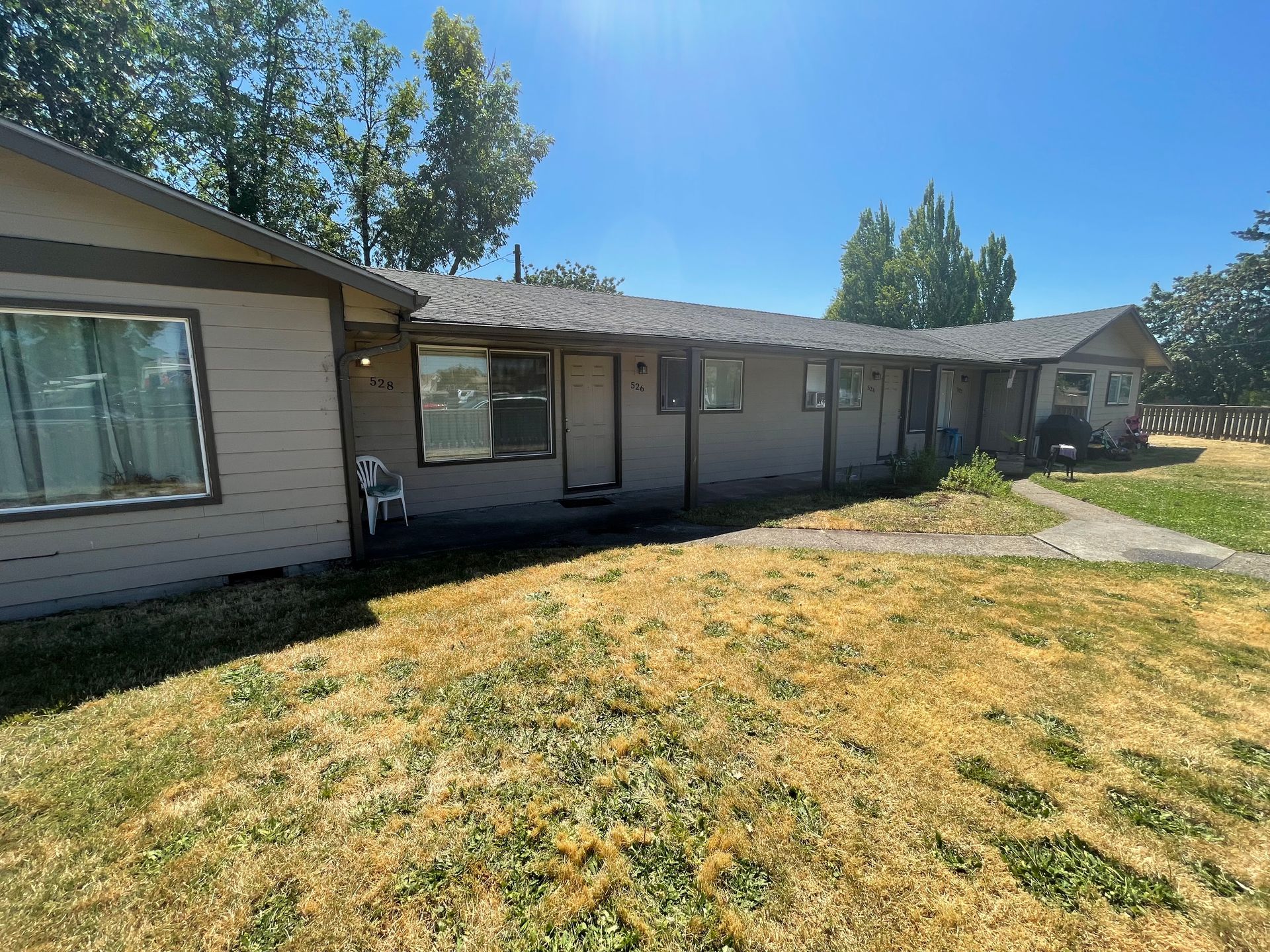 A house with a lot of windows and a lot of grass in front of it.
