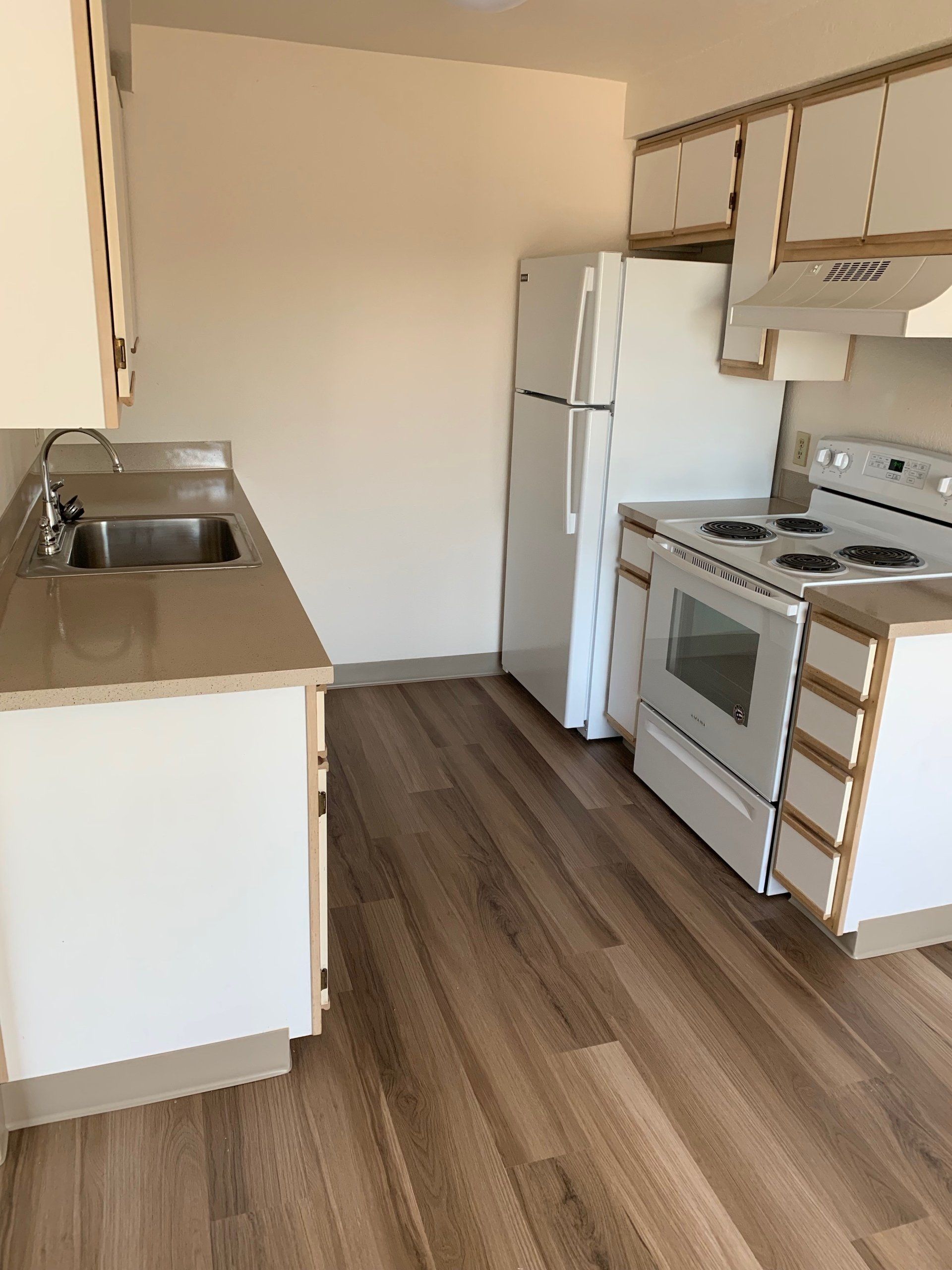 A kitchen with a refrigerator stove and sink