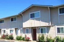 A large apartment building with a lot of windows on a sunny day.