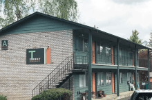 A large apartment building with stairs leading up to the second floor.
