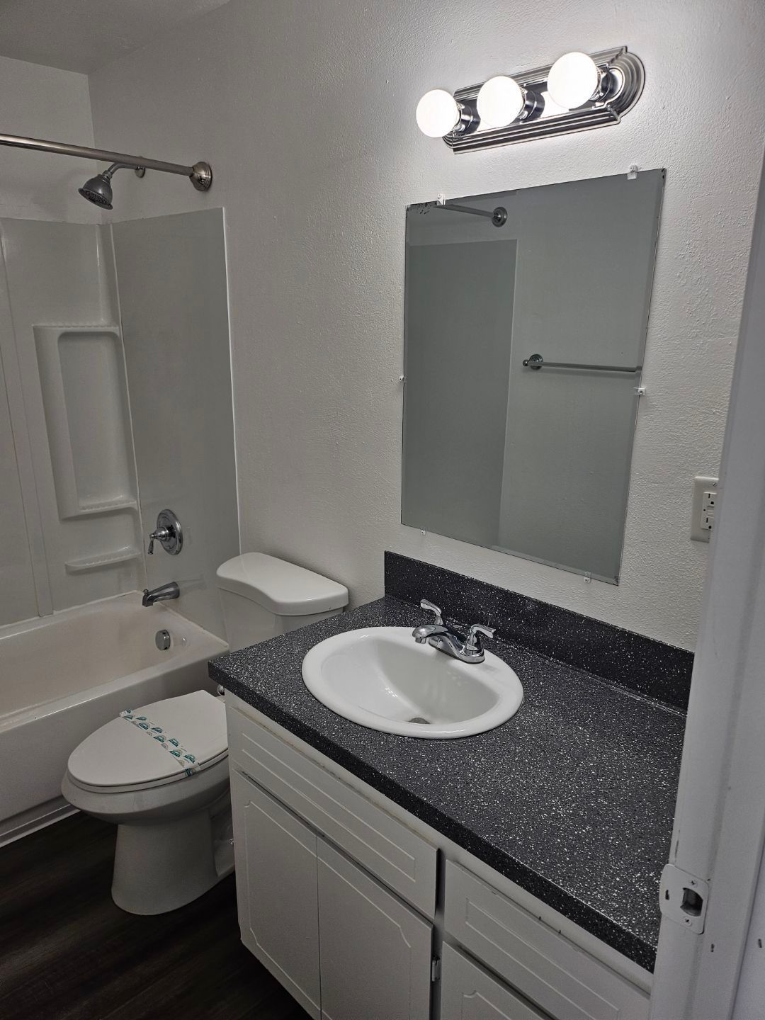 A bathroom with a sink , toilet , bathtub and mirror.