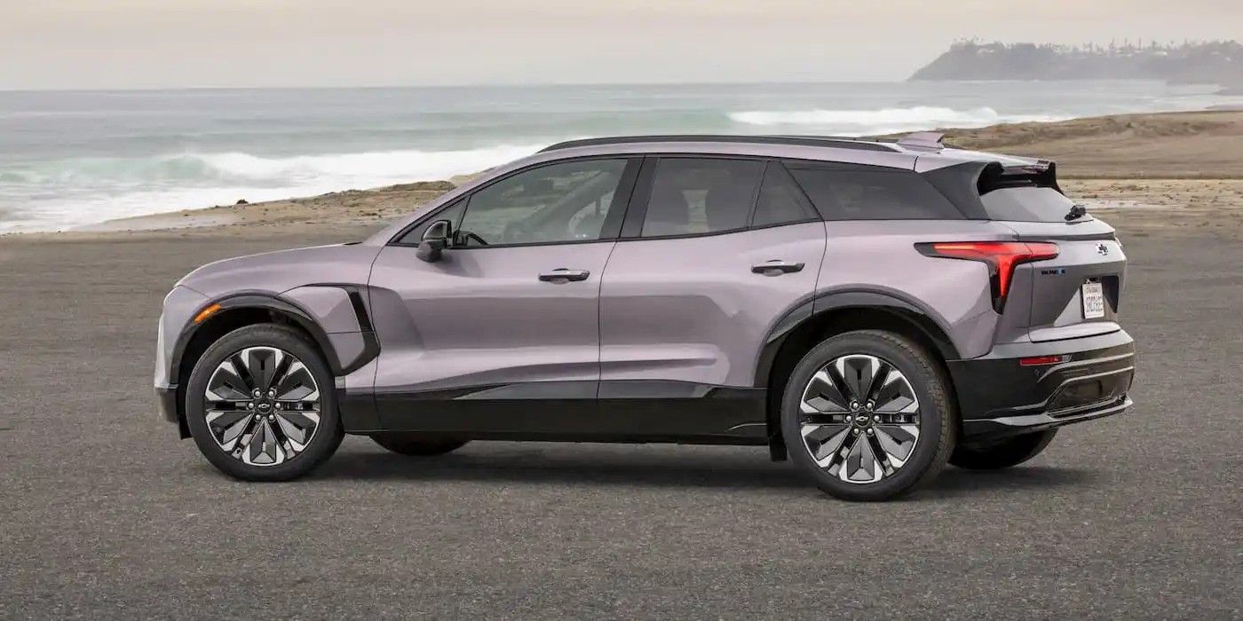 Gray SUV parked on a beach road with ocean waves in the background