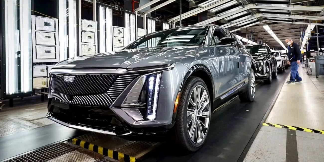 Silver luxury SUV on an assembly line in a bright auto factory