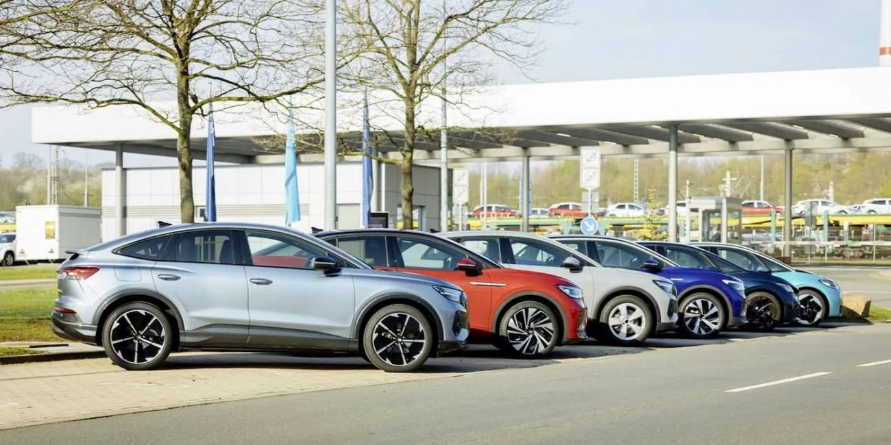 Row of parked sports cars in silver, red, and blue outside a dealership