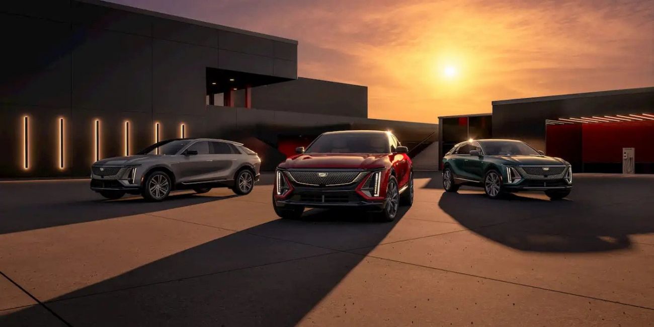 Three luxury cars parked outside a modern building at sunset