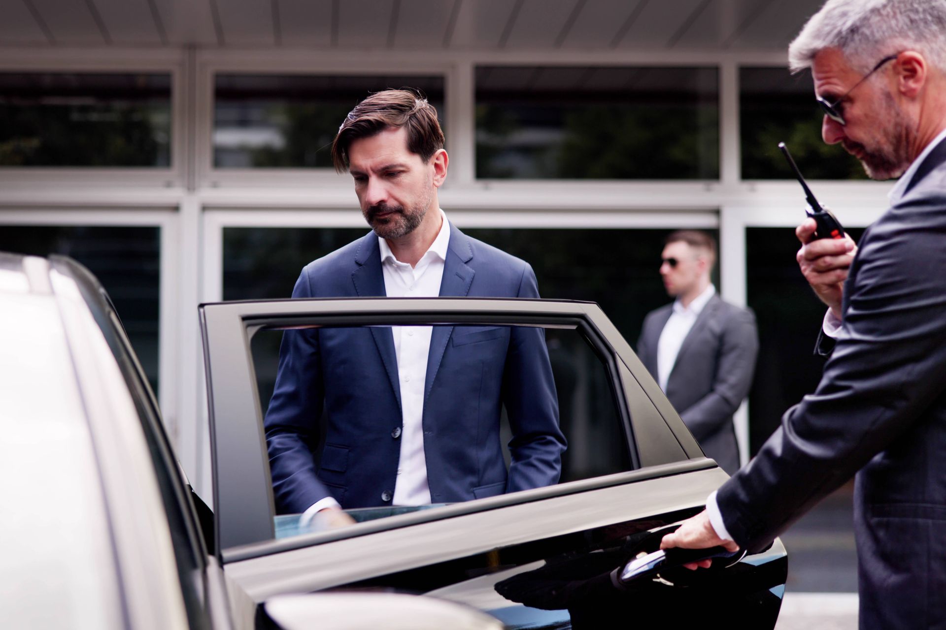 Executive protection specialist opening car door for client near Lexington, KY