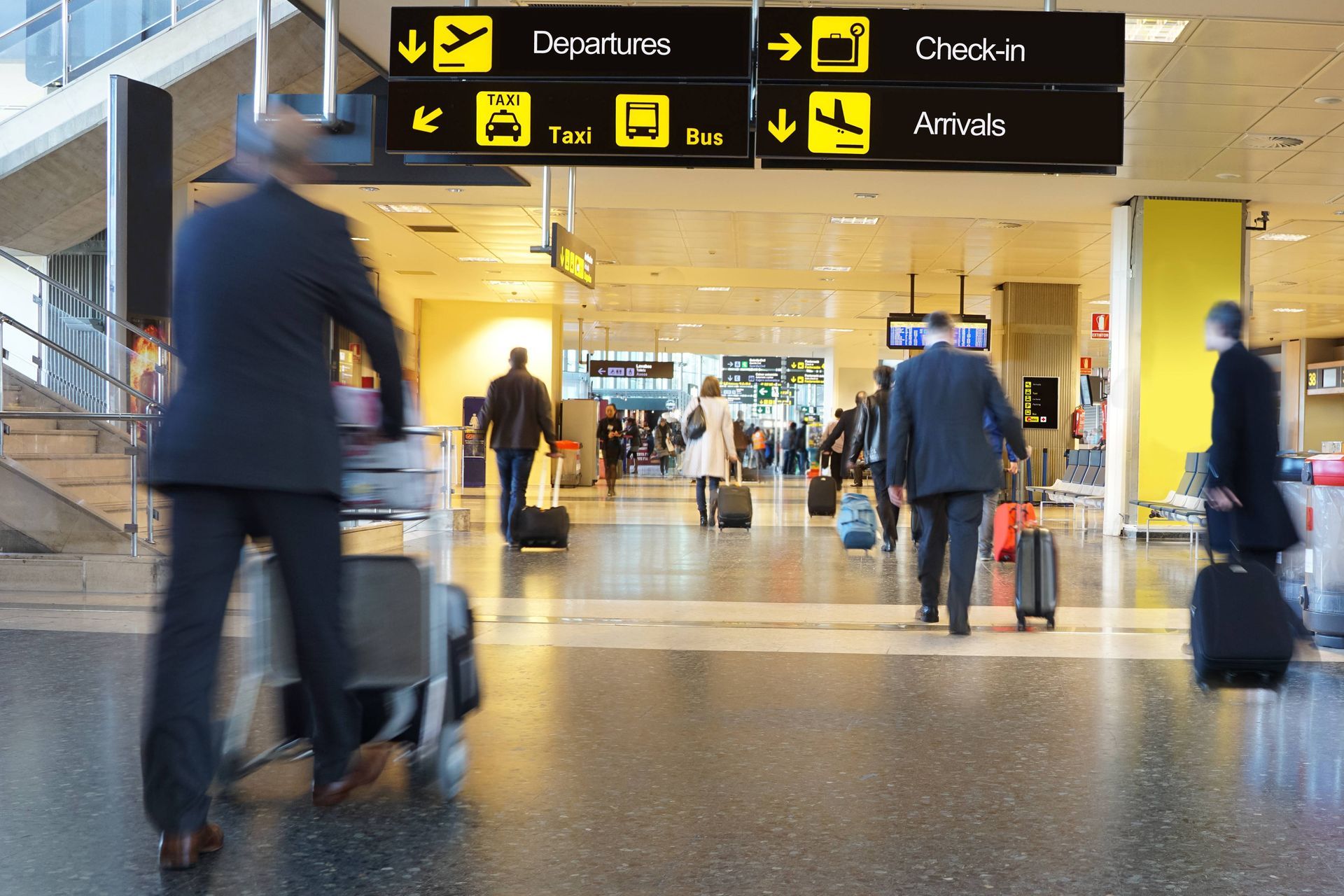 People with luggage walking through an airport following gate signs at Decisive Action near Lexingto