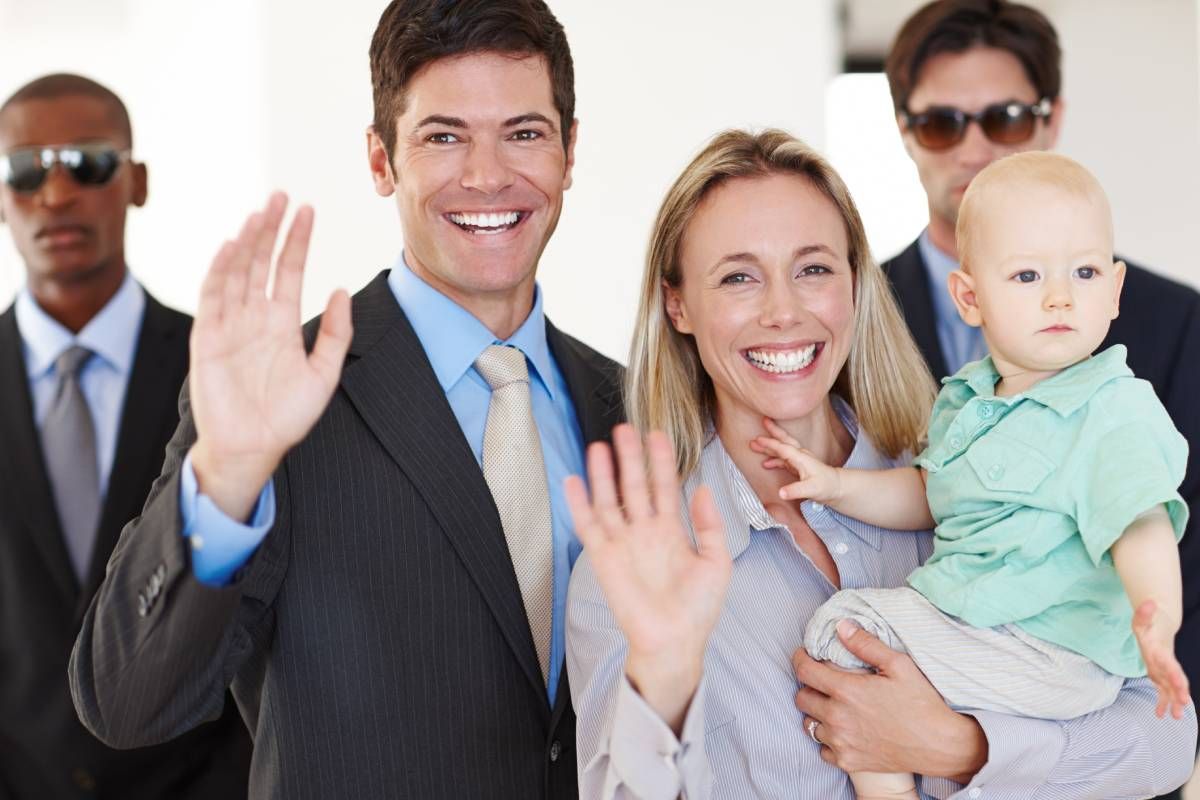 A smiling executive and his wife holding a baby receiving protection services near Lexington, KY