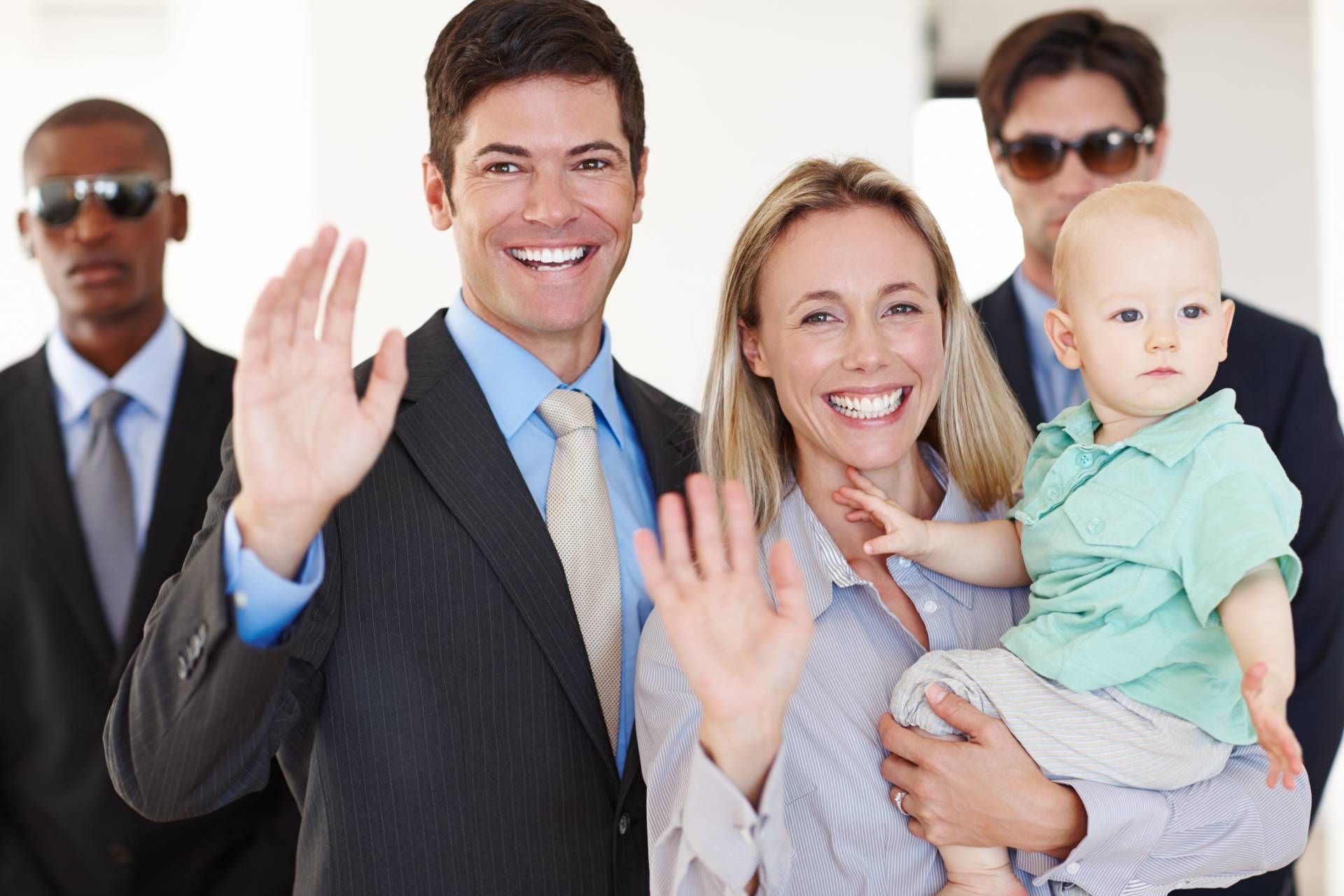 A smiling executive and his wife holding a baby receiving protection services near Lexington, KY