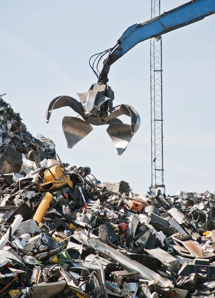 Scrap metal pile with a crane claw overhead — B & B Scrap Metal in Noosaville, QLD