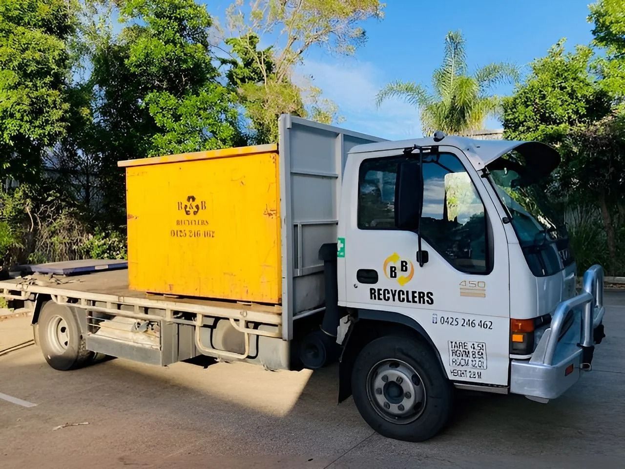 Yellow Recycling Truck With a Skip Bin on the Back, Parked Outdoors — B & B Scrap Metal in Noosaville, QLD