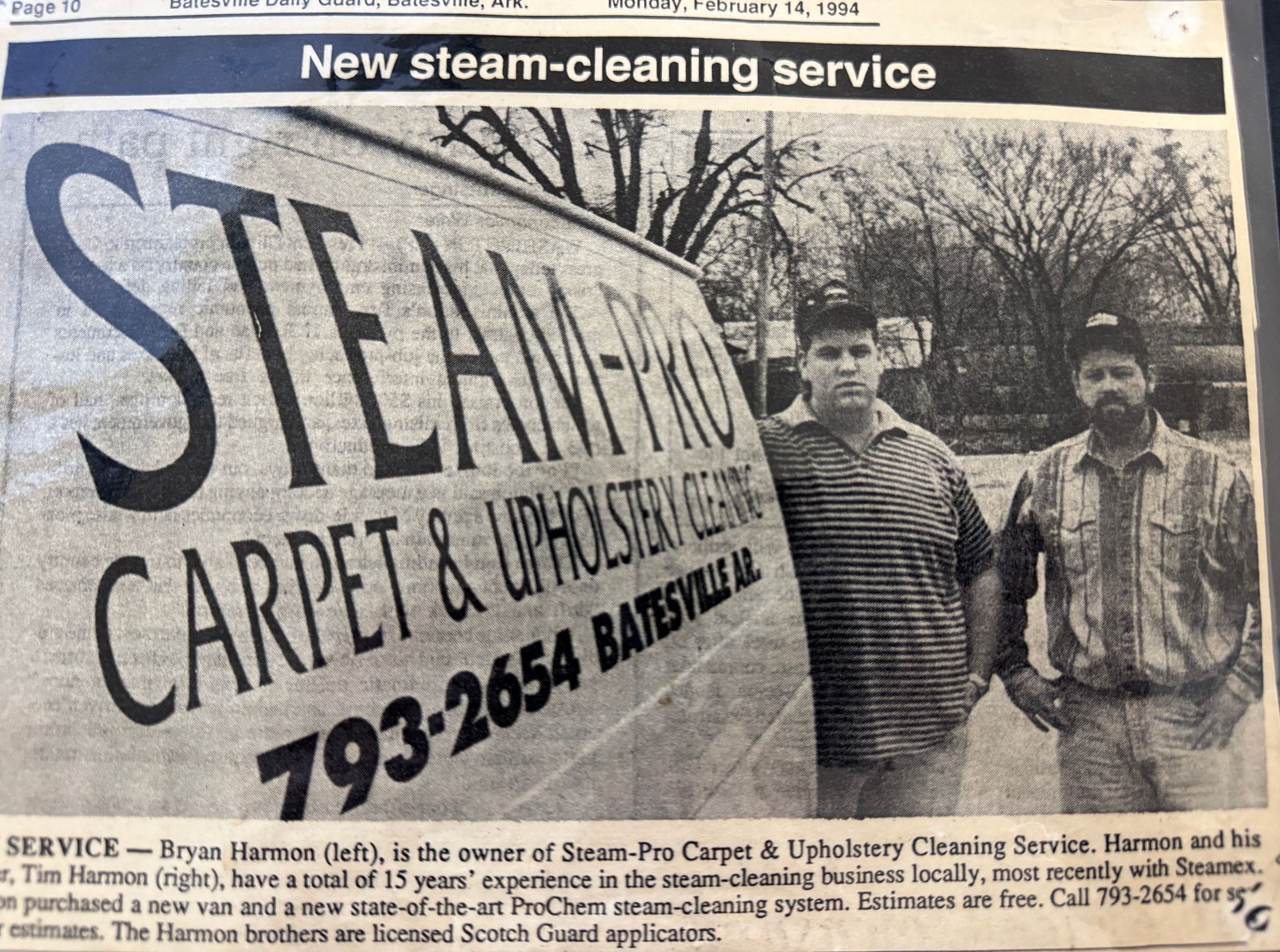 Newspaper ad: Two men stand beside a van labeled