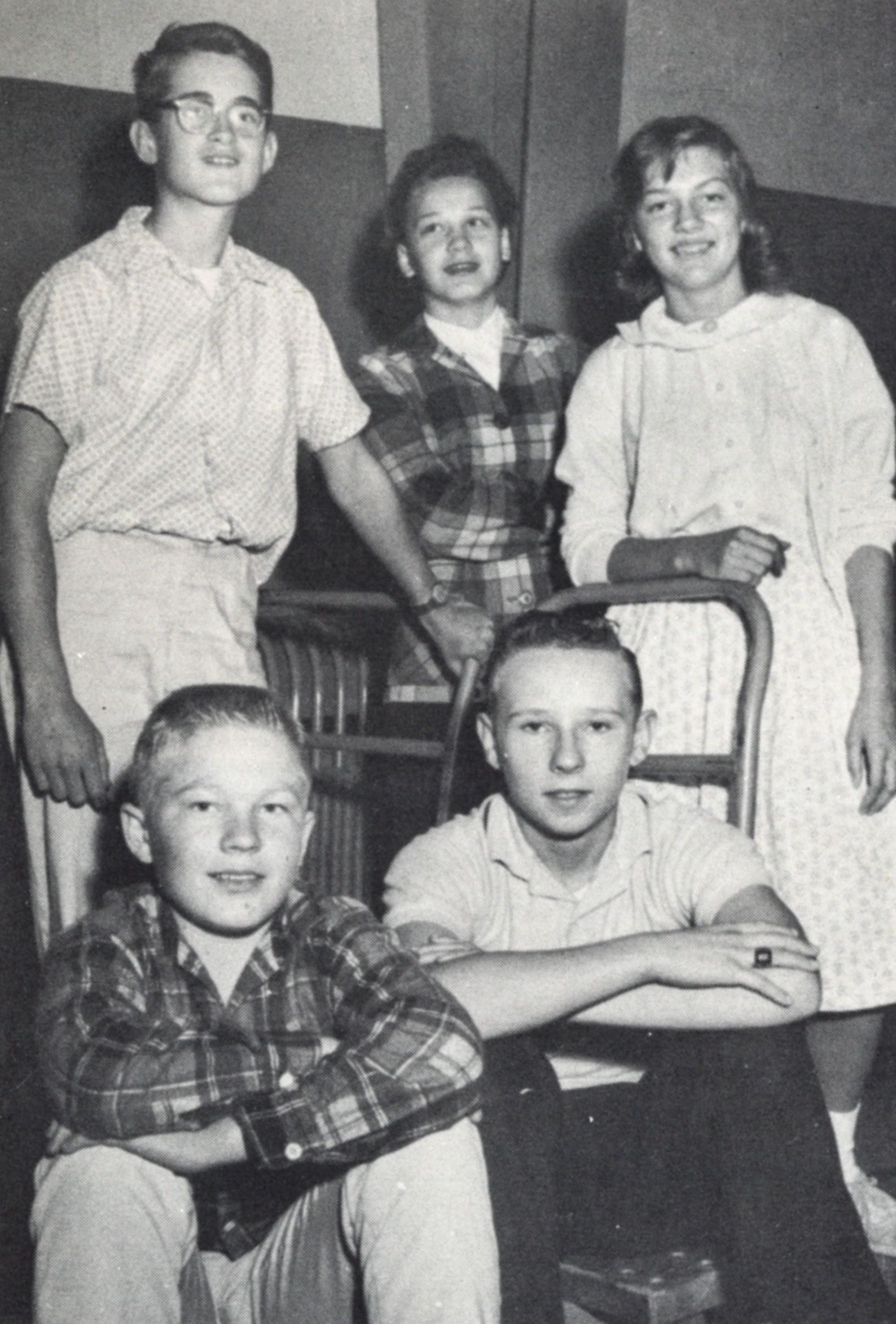 Five smiling students - two of whom are seated