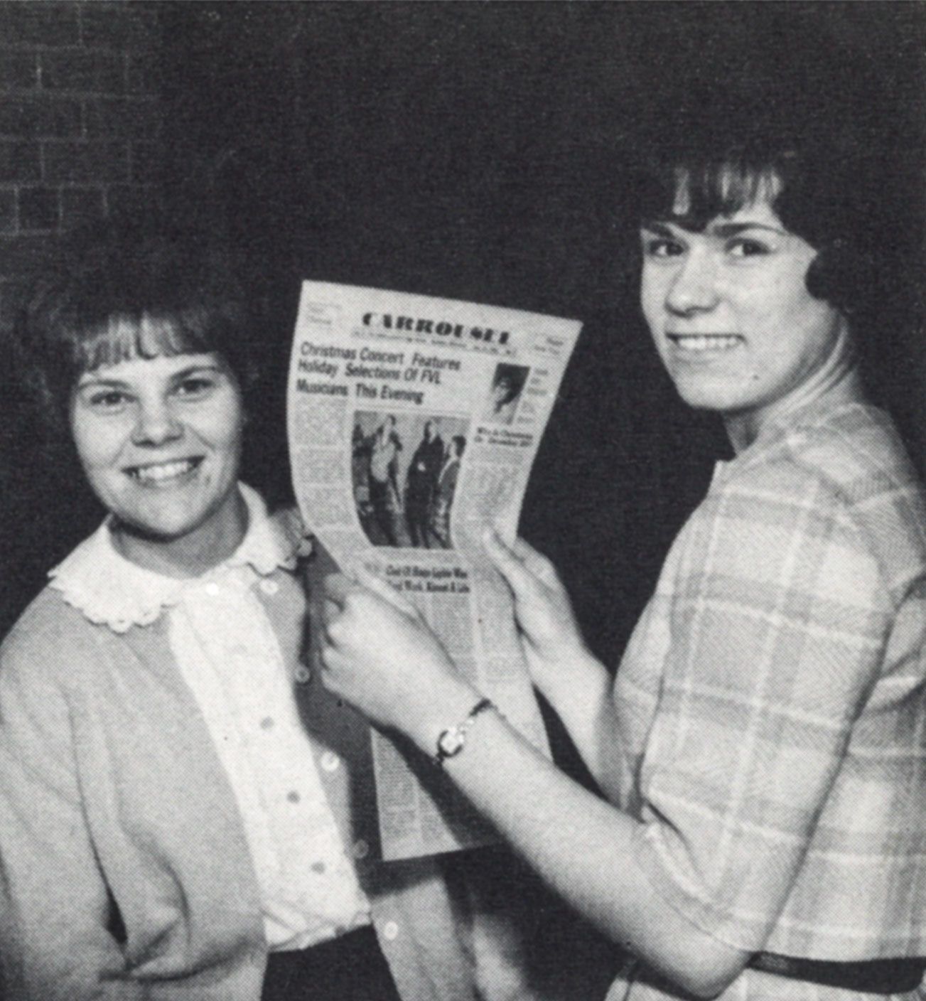 Two female students holding up the Carrousel newspaper.