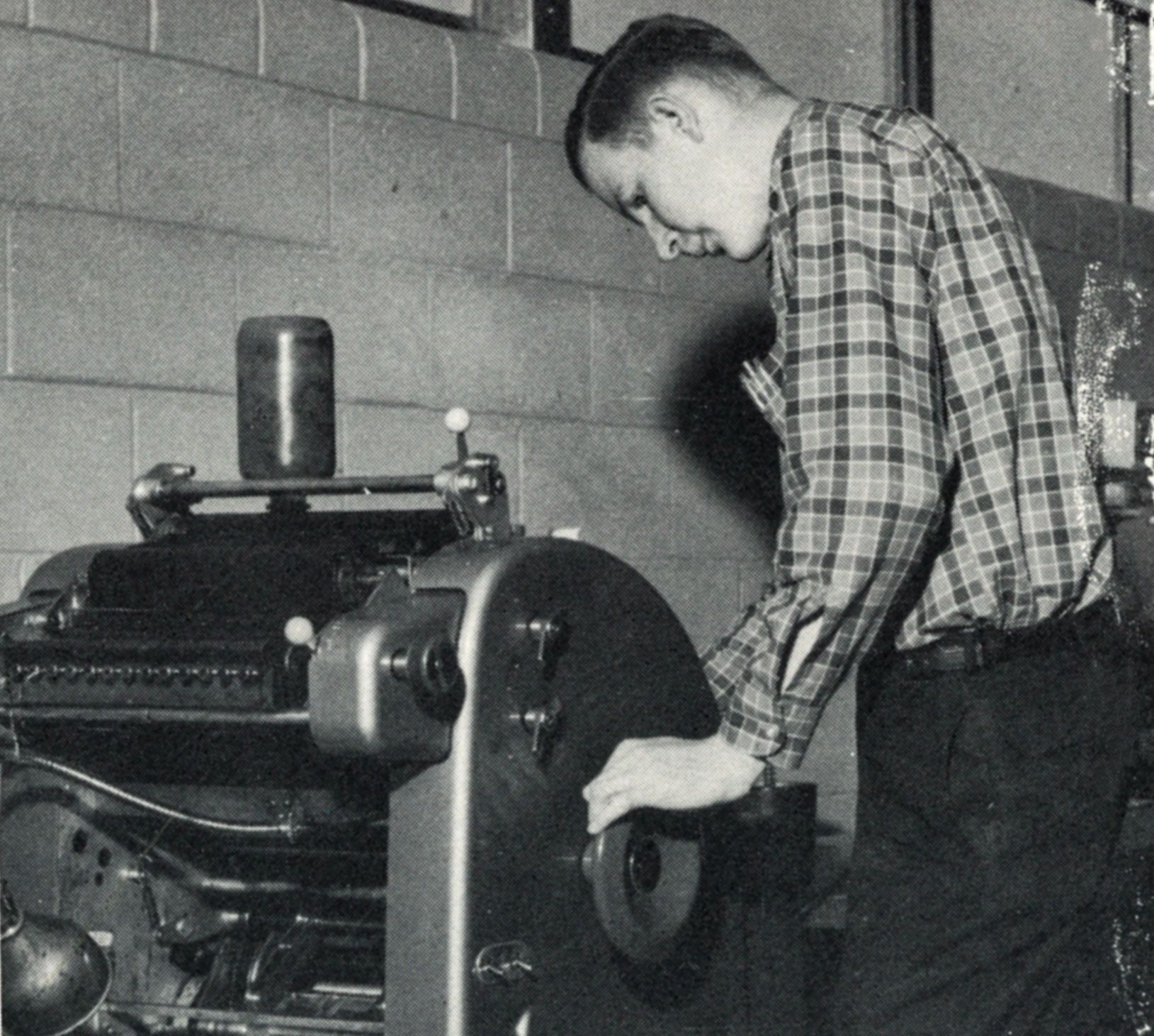 Male looking at a printing press.