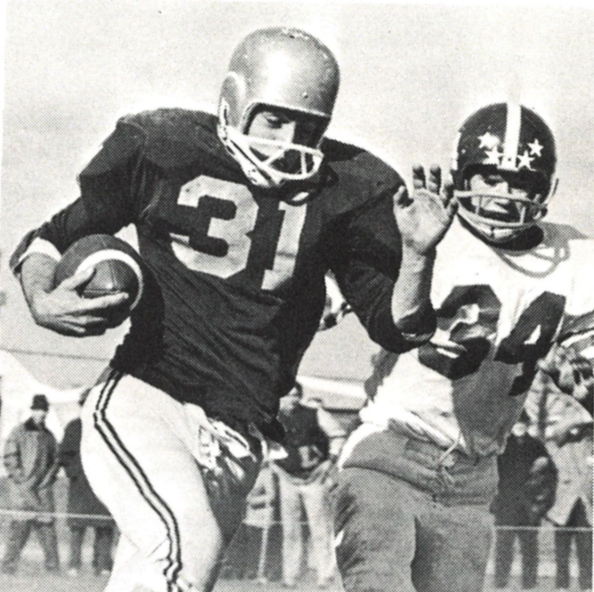 Football player (#31) running with a football and being pursued by the opponent.