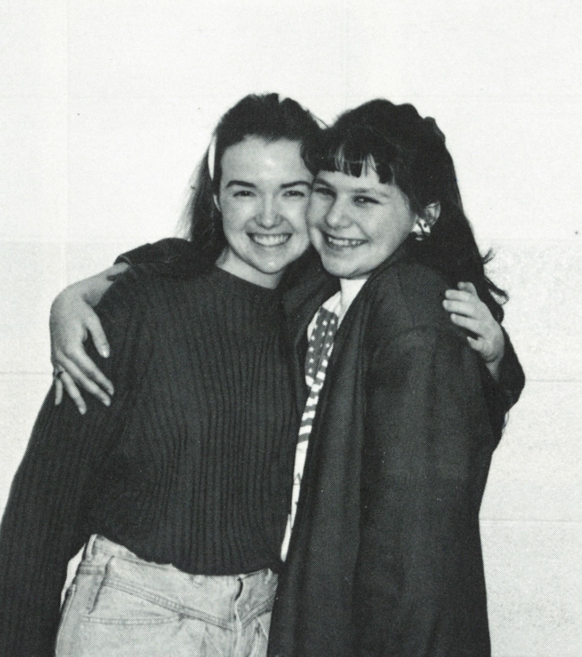 Two happy girls with their arms around each other