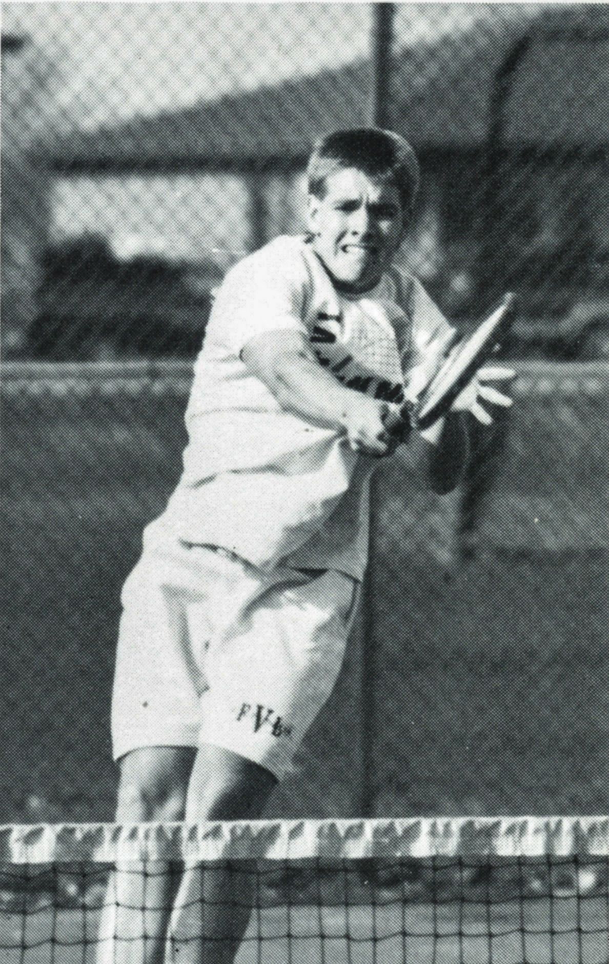 Boy playing tennis with intensity