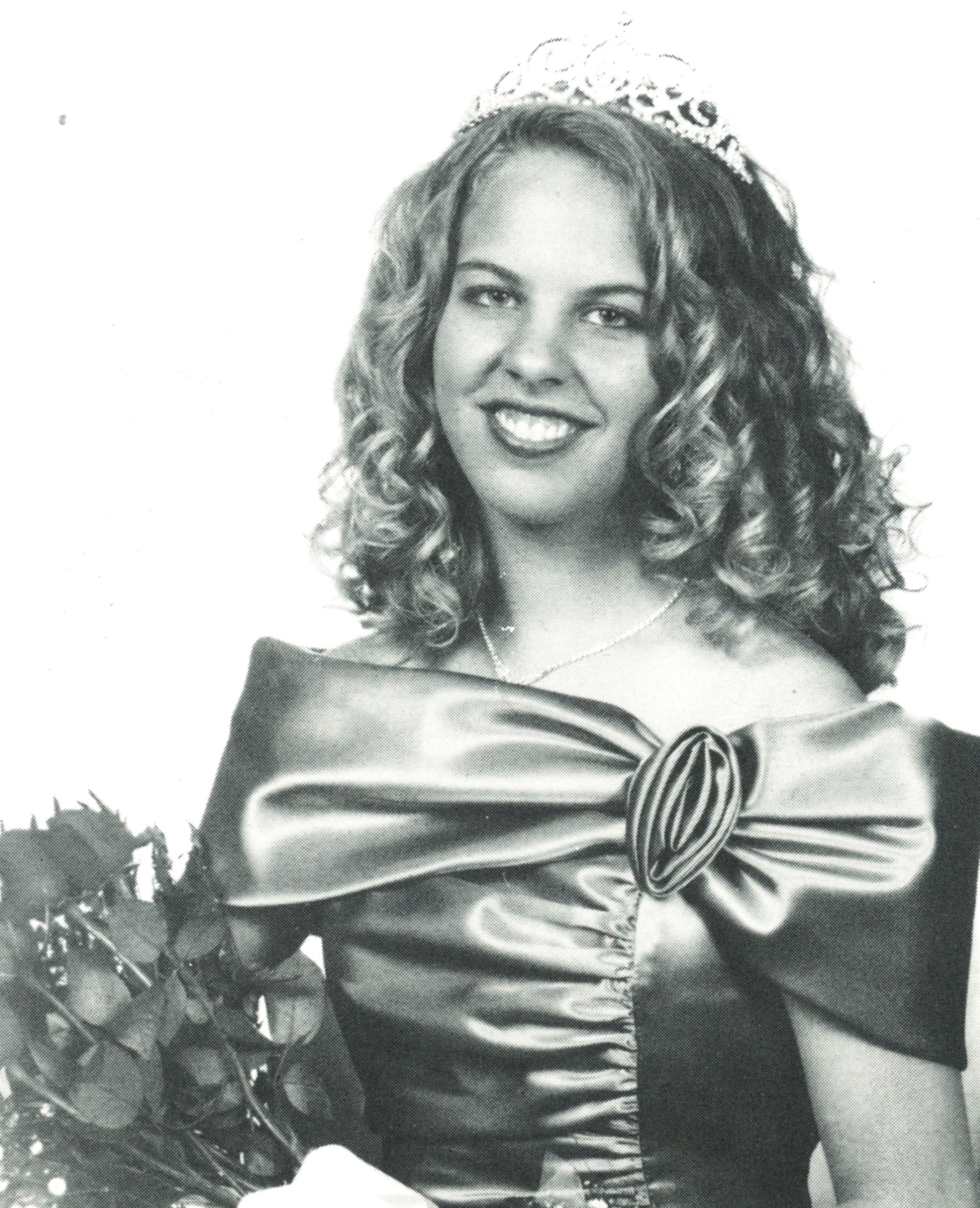 Smiling queen in formal dress, wearing a crown