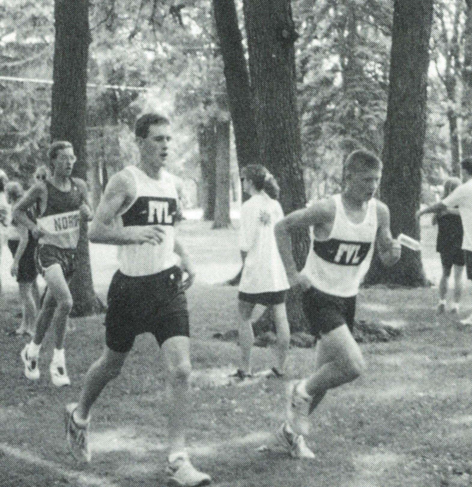 Boys cross country team running a race through the woods