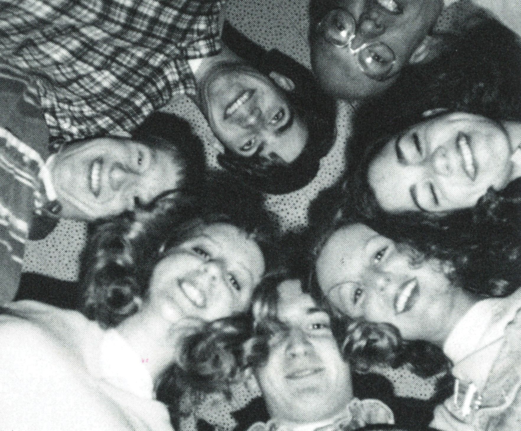 Circle of smiling faces looking down at the camera