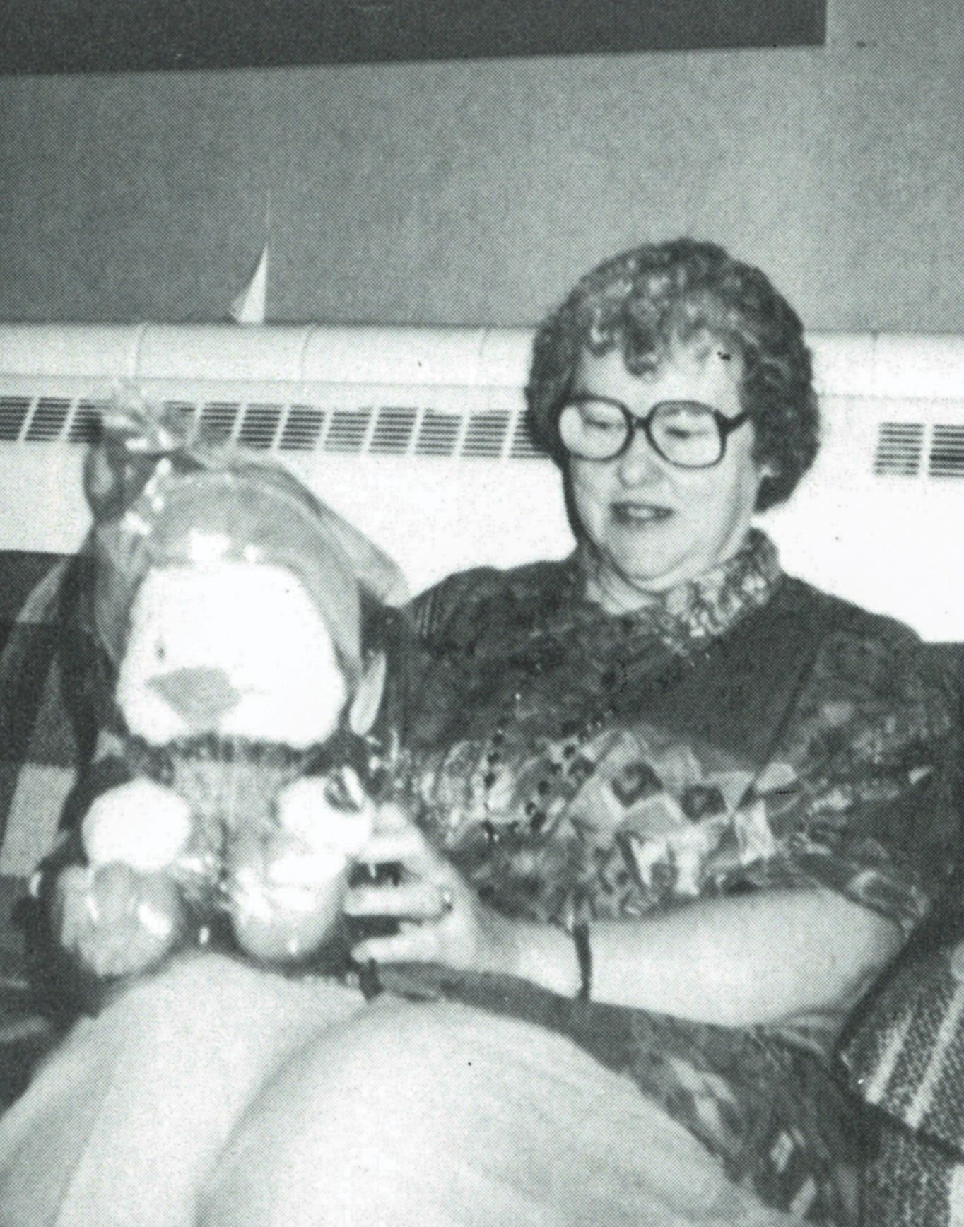 Mrs. Sackenheim, sitting in a chair and holding a stuffed animal