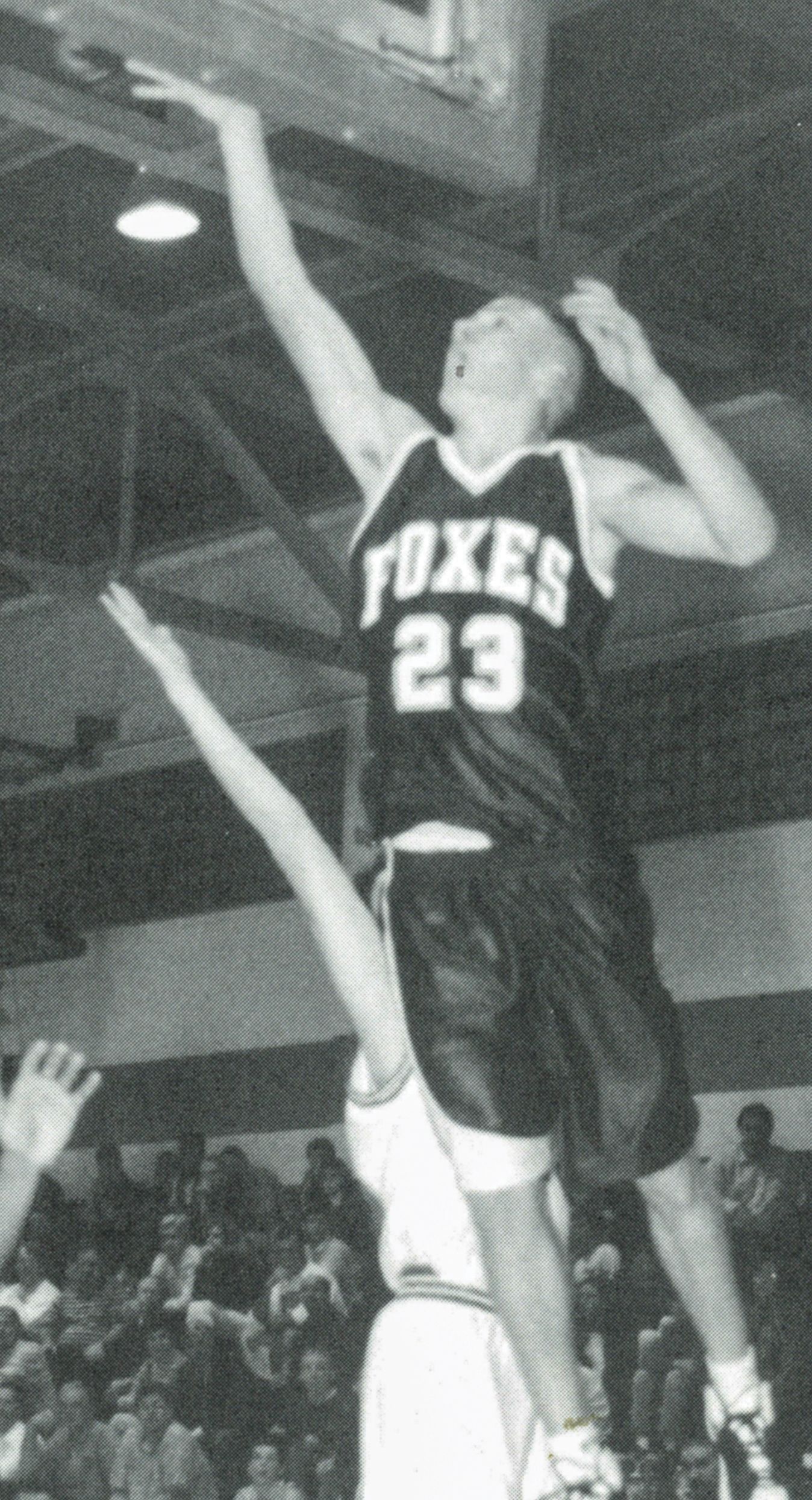 Boys basketball payer, in the air, taking a shot for a basket