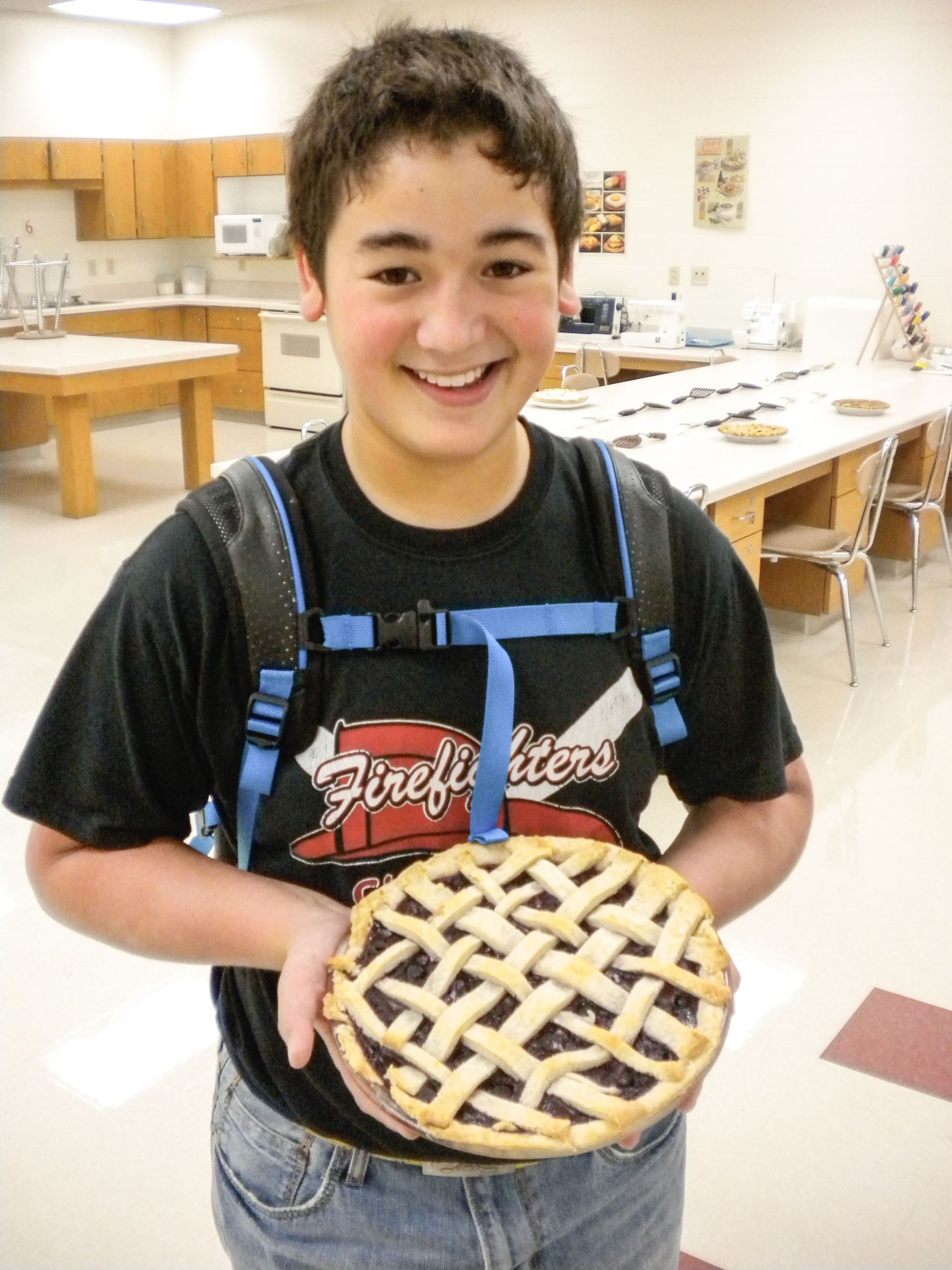 Smiling boy holding a pie with a lattice-top crust